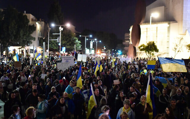 Des manifestants brandissent des pancartes et des drapeaux lors d'une marche de protestation contre l'invasion russe de l'Ukraine, à Tel Aviv, le 26 février 2022. (Tomer Neuberg/Flash90)
