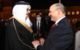 Le Premier ministre Naftali Bennett, à droite, accueilli par le ministre bahreïni des Affaires étrangères Abdullatif bin Rashid Al-Zayani dans la capitale de Manama, le 14 février 2022. (Crédit : Haim Zach/GPO)