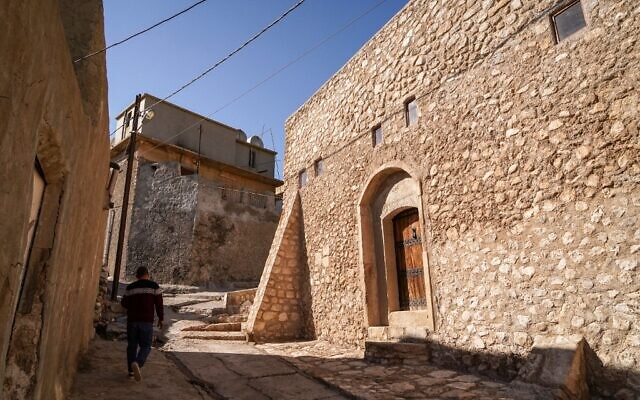 Un homme marche à l'extérieur de la synagogue Prophet Nahum (dont la forme actuelle date de l'année 1796), dans la ville d'al-Qosh, au nord de l'Irak, à une cinquantaine de kilomètres au nord de Mossoul, le 3 février 2022. (Crédit : Ismael ADNAN / AFP)