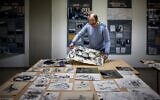 Directeur français du Musée de la Résistance et de la Déportation en Ardèche, Rémi Fourche examine des dessins et des affiches envoyés par un donateur anonyme à Le Teil, dans le sud de la France, le 1er mars 2022. (Crédit : JEFF PACHOUD / AFP)