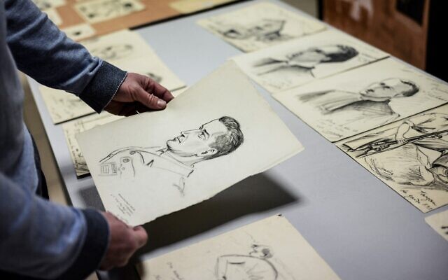 Directeur français du Musée de la Résistance et de la Déportation en Ardèche, Rémi Fourche examine des dessins et des affiches envoyés par un donateur anonyme à Le Teil, dans le sud de la France, le 1er mars 2022. (Crédit : JEFF PACHOUD / AFP)