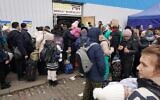 Des réfugiés ukrainiens se rassemblent au centre de distribution de Korczowa, en Pologne, le 5 mars 2022. (Janek Skarzynski/AFP)