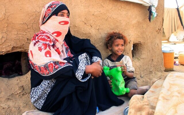 Une femme yéménite est assise avec un enfant dans un camp de fortune pour personnes déplacées dans le nord de la province de Hajjah, le 6 mars 2022. (Crédit : ESSA AHMED / AFP) Une femme yéménite est assise avec un enfant dans un camp de fortune pour personnes déplacées dans le nord de la province de Hajjah, le 6 mars 2022. (Crédit : ESSA AHMED / AFP)