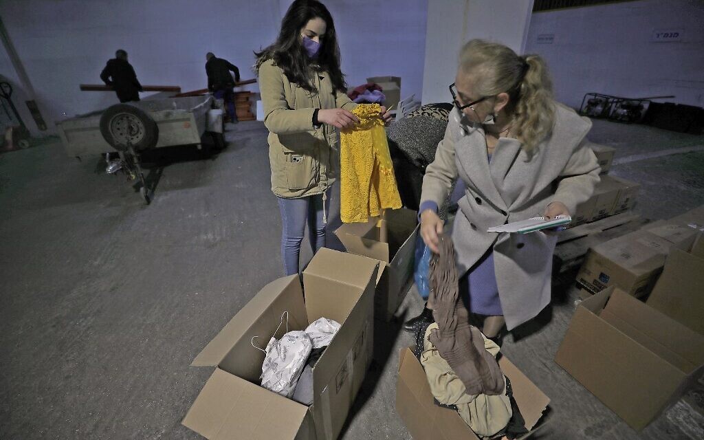 Des bénévoles de la ville de Nof Hagalil, dans le nord d'Israël, rassemblent des objets donnés pour accueillir des réfugiés fuyant la guerre en Ukraine, le 6 mars 2022. (Crédit : JALAA MAREY / AFP)