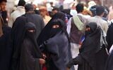 Des femmes yéménites marchent dans le marché de la Vieille Ville de Sanaa, la capitale tenue par les rebelles houthis, le 2 mars 2020. (Crédit : MOHAMMED HUWAIS / AFP)