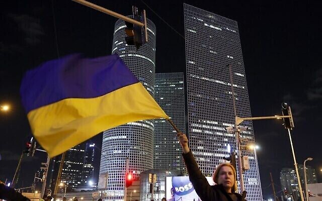 Une femme brandit un drapeau ukrainien lors d’une manifestation contre l’invasion militaire de l’Ukraine par la Russie, à Tel-Aviv, sur la côte méditerranéenne d’Israël, le 12 mars 2022. (JACK GUEZ / AFP)
