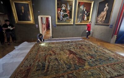 La conservatrice du musée du Louvre, Anne Labourdette (à gauche), inspecte la tapisserie "Le cortège triomphal de Pompée" au château de Blois, dans le centre de la France, le 15 mars 2022. - Le chef d'état-major nazi allemand Hermann Goering a acquis la tapisserie qui retrace l'histoire de Pompée auprès de Renée Gérard, un antiquaire français, en 1942 pour 3 millions de francs. Elle a été remise par Remise Allemagne à la France en octobre 2021. (Crédit : GUILLAUME SOUVANT / AFP)