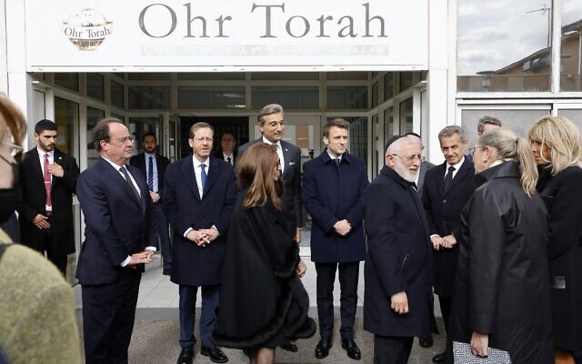 Le président français Emmanuel Macron (5e), l'ancien président français François Hollande (2e), le président israélien Isaac Herzog (3e), le résident du CRIF de la région Midi-Pyrénées, Franck Touboul (C), Yaacov Monsonego (4ème), directeur de l'école et père de Myriam tuée par Merah, l'ancien président français Nicolas Sarkozy (3e à droite) et l'épouse du président français Brigitte Macron (droite) devant l'entrée du collège et du lycée Ohr Torah à Toulouse, dans le sud de la France, le 20 mars 2022, avant le début des cérémonies commémorant le dixième anniversaire des attentats perpétrés par Mohamed Merah qui ont tué sept personnes en 2012. (Crédit : Ludovic MARIN / POOL / AFP)