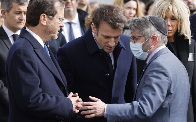 Le président français Emmanuel Macron, entouré de son épouse Brigitte Macron et du ministre français de l'Intérieur Gérald Darmanin, écoute le président israélien Isaac Herzog et le grand rabbin de France Haïm Korsia au collège et au lycée Ohr Torah à Toulouse, dans le sud de la France, le 20 mars 2022, dans le cadre d'une cérémonie commémorant le dixième anniversaire des attentats perpétrés par Mohamed Merah qui ont fait sept morts en 2012. (Crédit : Ludovic MARIN / POOL / AFP)