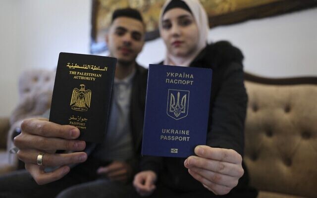 L'Ukrainienne Viktoria Saidam (R), accompagnée de son mari palestinien Ibrahim Saidam, montrent leurs passeports dans leur maison familiale du camp de réfugiés de Bureij, dans le centre de la bande de Gaza, le 22 mars 2022. (Crédit : SAID KHATIB / AFP) L'Ukrainienne Viktoria Saidam (R), accompagnée de son mari palestinien Ibrahim Saidam, montrent leurs passeports dans leur maison familiale du camp de réfugiés de Bureij, dans le centre de la bande de Gaza, le 22 mars 2022. (Crédit : SAID KHATIB / AFP)