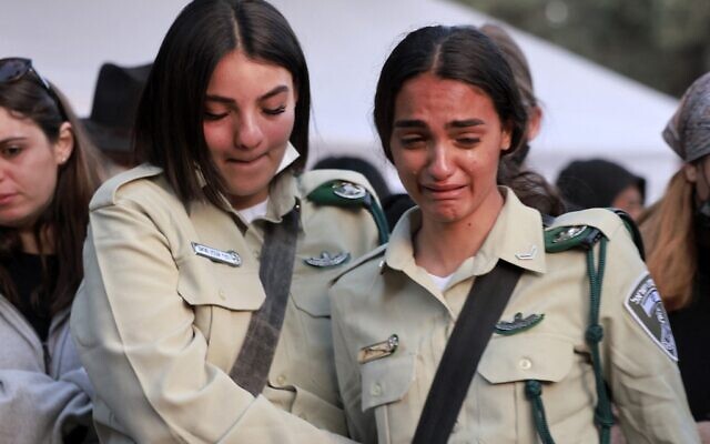 Des collègues de Shirel Aboukrat, tuée dans un attentat à Hadera, la veille, lors de ses funérailles au cimetière de Netanya, le 28 mars 2022. (Crédit :  Menahem KAHANA / AFP)