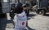 Un enfant à côté d'un sac de farine lors d'une distribution d'aide alimentaire dans un centre de l'UNRWA (l'Office de secours et de travaux des Nations unies pour les réfugiés palestiniens) à Khan Younès, dans la bande de gaza, le 2 février 2020. (Crédit : SAID KHATIB/ AFP/ File)