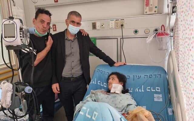 Manwar Burqan, 11 ans, après avoir été heurtée par une grenade assourdissante de la police, aux côtés de son père, à l'extrême gauche, et du député Meretz de gauche Mossi Raz, au centre, à l'hôpital Hadassah, le 1er mars 2021.(Crédit : Noa Pinto)