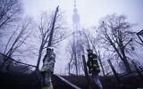 Des combattants ukrainiens sous une tour de télévision dans le cimetière juif situé dans le mémorial de la Shoah de Babi Yar, à Kiev, le 1er mars 2022. (Crédit : State Emergency Service of Ukraine)