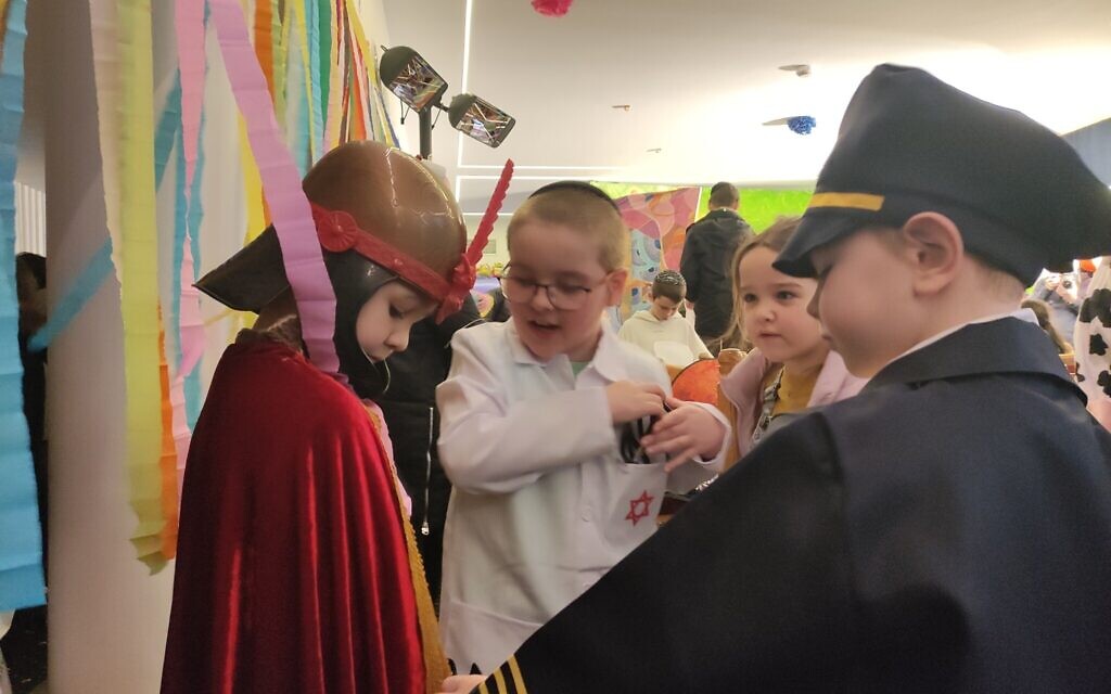 Des enfants ukrainiens fêtent Pourim à Neptun, en Roumanie, le 16 mars 2022. (Crédit : Marcel Gascon Barbera/JTA)