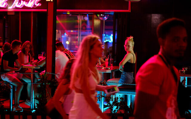 Des touristes dans un pub de la station balnéaire d'Ayia Napa à Chpre, une île de l'Est de la méditerranée, le 17 juillet 2019. (Crédit : AP/Petros Karadjias)
