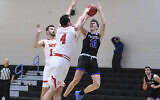 Le défenseur de l'équipe Yeshiva, Ryan Turell (numéro 11), effectue un tir par-dessus l’attaquant du Worcester Polytechnic Institute, Jake Wisniewski (numéro 4), pendant la deuxième moitié d’un match de basketball collégial DIII de la NCAA sans spectateurs, le 6 mars 2020, à Baltimore, Md. (AP Photo/Terrance Williams)