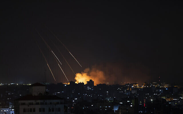 Des colonnes de fumée s'élèvent dams le ciel après des frappes de missiles israéliennes sur la ville de Gaza, le 13 mai 2021. (Crédit : AP/Khalil Hamra) Des colonnes de fumée s'élèvent dams le ciel après des frappes de missiles israéliennes sur la ville de Gaza, le 13 mai 2021. (Crédit : AP/Khalil Hamra)