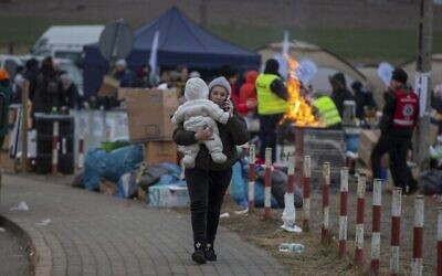 Des réfugiés, majoritairement des femmes avec enfants, parviennent à la frontière au point de passage frontière de Medyka, en Pologne, le dimanche 6 mars 2022. (AP Photo/Visar Kryeziu)