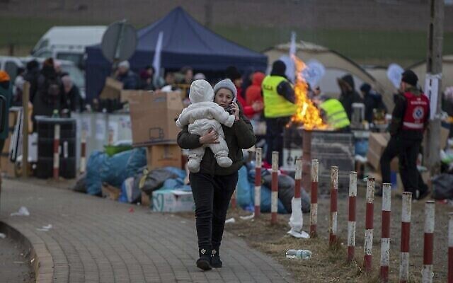Des réfugiés, majoritairement des femmes avec enfants, parviennent à la frontière au point de passage frontière de Medyka, en Pologne, le dimanche 6 mars 2022. (AP Photo/Visar Kryeziu)