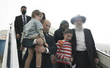 Le Premier ministre israélien Naftali Bennett accueillant un groupe d'orphelins de la ville ukrainienne de Zhytomyr, à l'arrivée des enfants à l'aéroport Ben Gurion, le 6 mars 2022. (Crédit : Maya Alleruzzo/AP Photo/Pool)