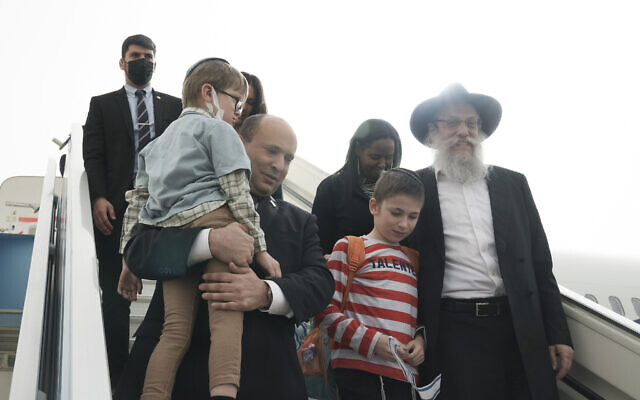 Le Premier ministre israélien Naftali Bennett accueillant un groupe d'orphelins de la ville ukrainienne de Zhytomyr, à l'arrivée des enfants à l'aéroport Ben Gurion, le 6 mars 2022. (Crédit : Maya Alleruzzo/AP Photo/Pool)