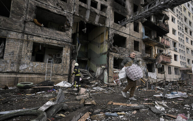 Un résident venu prendre ses effets personnels dans un immeuble frappé par des tirs d'artiellerie à Kiev, en Ukraine, le 14 mars 2022. (Crédit : AP Photo/Vadim Ghirda) Un résident venu prendre ses effets personnels dans un immeuble frappé par des tirs d'artiellerie à Kiev, en Ukraine, le 14 mars 2022. (Crédit : AP Photo/Vadim Ghirda)