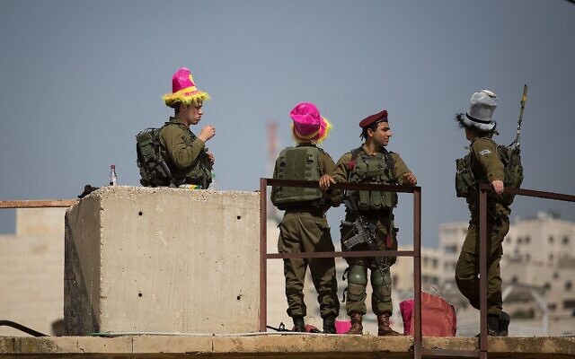 Des soldats israéliens montent la garde lors du défilé annuel marquant la fête juive de Pourim dans la ville de Hébron en Cisjordanie, le 1er mars 2018. (Crédit : Hadas Parush/Flash90) Des soldats israéliens montent la garde lors du défilé annuel marquant la fête juive de Pourim dans la ville de Hébron en Cisjordanie, le 1er mars 2018. (Crédit : Hadas Parush/Flash90)