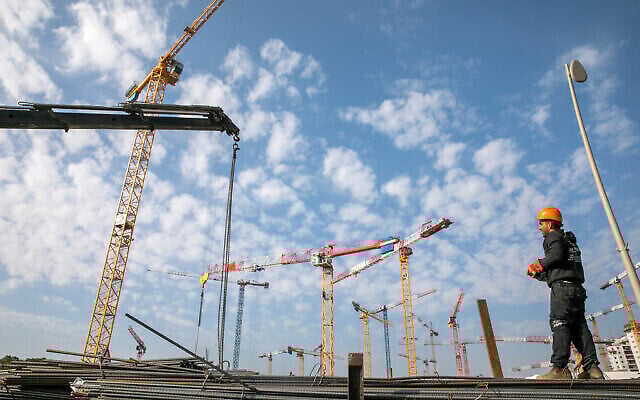Un chantier de construction dans la ville israélienne de Beer Yaakov, dans le centre du pays, où de nouveaux logements sont en cours de construction, le 22 février 2022. (Crédit : Yossi Aloni/Flash90 Un chantier de construction dans la ville israélienne de Beer Yaakov, dans le centre du pays, où de nouveaux logements sont en cours de construction, le 22 février 2022. (Crédit : Yossi Aloni/Flash90