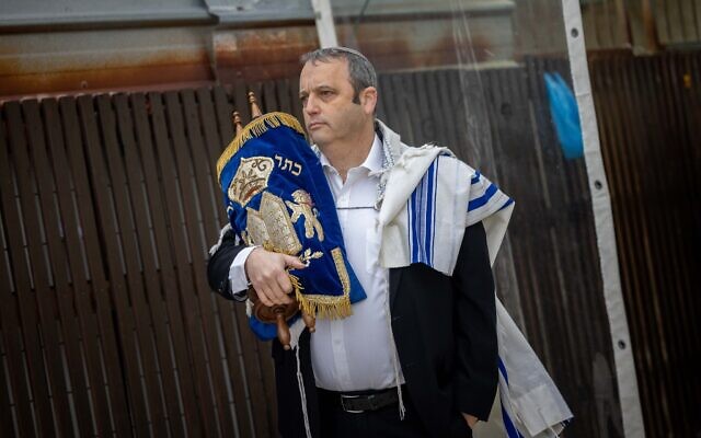 Illustration : Le député Gilad Kariv tenant un rouleau de Torah pendant les prières de Rosh Hodesh au mur Occidental, dans la Vieille Ville de Jérusalem, le 4 mars 2022. (Crédit : Yonatan Sindel/Flash90)