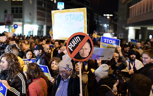 Des manifestants brandissent des pancartes et des drapeaux pendant une manifestation contre l'invasion russe de l'Ukraine à Tel Aviv, le 5 mars 2022. (Crédit : Tomer Neuberg/Flash90)