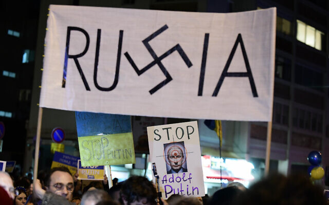 Des manifestants brandissent des pancartes et des drapeaux pendant une manifestation contre l'invasion russe de l'Ukraine à Tel Aviv, le 5 mars 2022. (Crédit : Tomer Neuberg/Flash90)