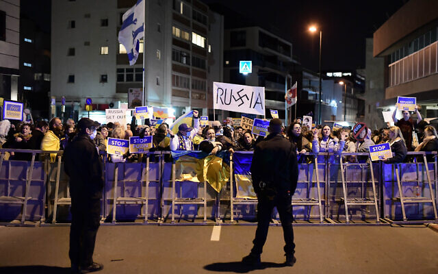 Des manifestants brandissent des pancartes et des drapeaux pendant une manifestation contre l'invasion russe de l'Ukraine à Tel Aviv, le 5 mars 2022. (Crédit : Tomer Neuberg/Flash90)