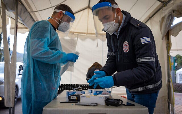 Un collaborateur du service de secours du Magen David Adom effectue un test antigénique rapide de la COVID-19, dans un centre de dépistage automobile du Magen David Adom installé à Jérusalem, le 22 mars 2022. (Crédit : Olivier Fitoussi/Flash90)
