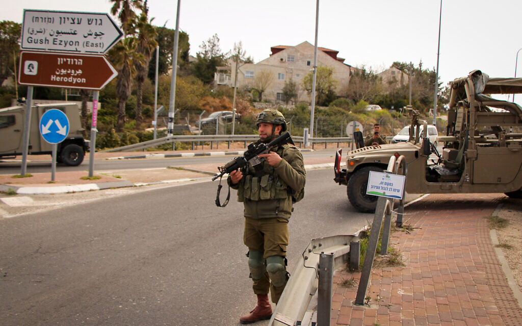Des soldats israéliens montent la garde à l'entrée de l'implantation d'Efrat, dans le centre de la Cisjordanie, le 29 mars 2022. (Crédit : Gershon Elinson/Flash90) Des soldats israéliens montent la garde à l'entrée de l'implantation d'Efrat, dans le centre de la Cisjordanie, le 29 mars 2022. (Crédit : Gershon Elinson/Flash90)