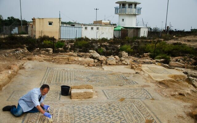 Un conservateur de l'Autorité israélienne des Antiquités travaillant sur la mosaïque "Jésus" qui fait partie d'une structure datant du IIIe ou du IVe siècle qui pourrait être l'une des premières églises chrétiennes découverte dans une prison à Megiddo, dans le nord d'Israël. (Crédit : Yoli Schwartz/IAA) Un conservateur de l'Autorité israélienne des Antiquités travaillant sur la mosaïque "Jésus" qui fait partie d'une structure datant du IIIe ou du IVe siècle qui pourrait être l'une des premières églises chrétiennes découverte dans une prison à Megiddo, dans le nord d'Israël. (Crédit : Yoli Schwartz/IAA)