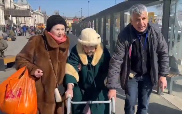 Le directeur de Yad Ezer L’Haver, Shimon Sabag et une survivante de la Shoah, en Ukraine, le 19 mars 2022. (Crédit : Capture d’écran/YouTube) Le directeur de Yad Ezer L’Haver, Shimon Sabag et une survivante de la Shoah, en Ukraine, le 19 mars 2022. (Crédit : Capture d’écran/YouTube)