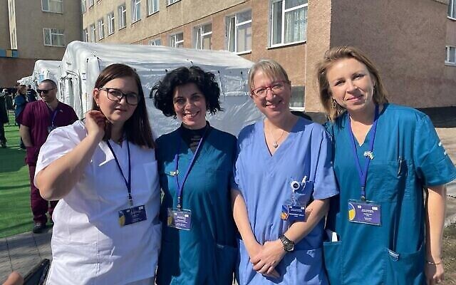 Personnel médical, représentants des gouvernements ukrainien et israélien et patients sont photographiés à l’hôpital de campagne israélien de Mostyska, en Ukraine, qui a ouvert ses portes le 22 mars 2022. (Crédit : Carrie Keller-Lynn/The Times of Israel)