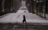 Des passants marchent sur une route déserte, pendant le couvre-feu, à Kiev, en Ukraine, le 1er mars  2022. (AP Photo/Emilio Morenatti)