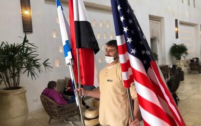 Un employé de l'hôtel Kedma enlève les drapeaux après le Sommet du Neguev, le 28 mars 2022. (Crédit : Lazar Berman/Times of Israel)