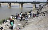 De jeunes volontaires irakiens participent à une campagne de nettoyage sur la rive du fleuve Tigre dans le district d'Adhamiyah de la capitale Bagdad, le 11 mars 2022. (Crédit : Sabah ARAR / AFP)