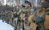 Des militaires du bataillon ukrainien Azov prient dans la deuxième plus grande ville d'Ukraine, Kharkiv, après l'invasion de l'Ukraine par la Russie, le 11 mars 2022. (Crédit : Sergey BOBOK / AFP)
