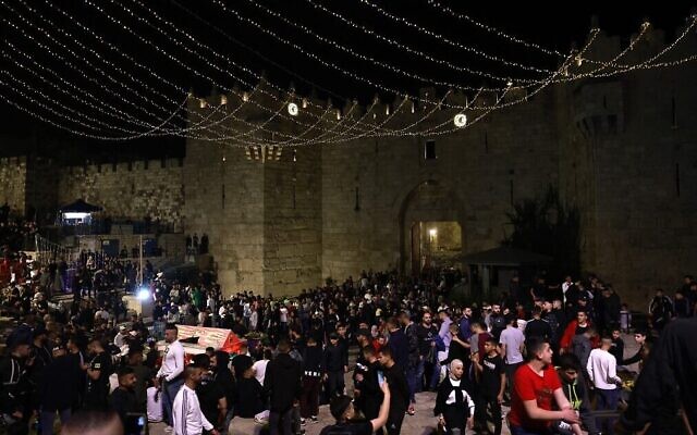 Les Palestiniens se réunissent aux abords de la porte de Damas, dans la Vieille Ville de Jérusalem, au premier soir du Ramadan, le 2 avril 2022. (Crédit :  Menahem KAHANA / AFP)