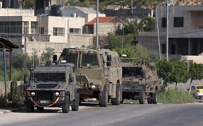 Photo d'illustration : Des véhicules de l'armée israélienne)à l'entrée du camp de réfugiés palestiniens de Nur Shams pendant un raid, le 10 avril 2022. (Crédit :JAAFAR ASHTIYEH / AFP)