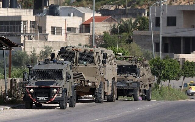 Photo d'illustration : Des véhicules de l'armée israélienne)à l'entrée du camp de réfugiés palestiniens de Nur Shams pendant un raid, le 10 avril 2022. (Crédit :JAAFAR ASHTIYEH / AFP)