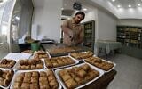 Un ouvrier de la confiserie Saleh Radhi Al Halwachi prépare des gâteaux bahreïnis au safran et à la cardamome, connus sous le nom de Khanfaroosh, dans sa boutique du village de Jid Hafs, dans la banlieue de Manama, la capitale bahreïnie, le 17 avril 2022.  (Crédit : Mazen Mahdi / AFP)