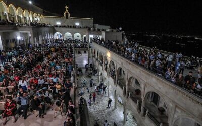 Des chrétiens orthodoxes irakiens célèbrent le samedi de Pâques à l'église de l'ancien monastère Mar Matta dans le village de Bashiqa, à quelque 30 km au nord-est de la ville de Mossoul, dans le nord de l'Irak, dans la nuit du 23 avril 2022. (Crédit : SAFIN HAMED / AFP)