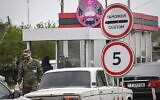 Un militaire transnistrien regarde des voitures dit :  dans la "République moldave de Transnistrie" au croisement de Varnita avec la Moldavie, le 28 avril 2022. (CréDaniel Mihailescu/AFP)