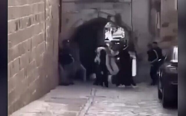 Un groupe de juifs ultra-orthodoxes attaqués par une foule alors qu'ils se rendent au Mur occidental dans la vieille ville de Jérusalem, le 17 avril 2022. (Crédit : Capture d'écran)