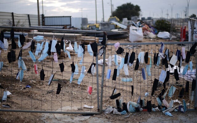 Des masques sont accrochés à une clôture à Glilot, dans le centre d'Israël, le 14 février 2022. (Crédit : Tomer Neuberg/Flash90) Des masques sont accrochés à une clôture à Glilot, dans le centre d'Israël, le 14 février 2022. (Crédit : Tomer Neuberg/Flash90)